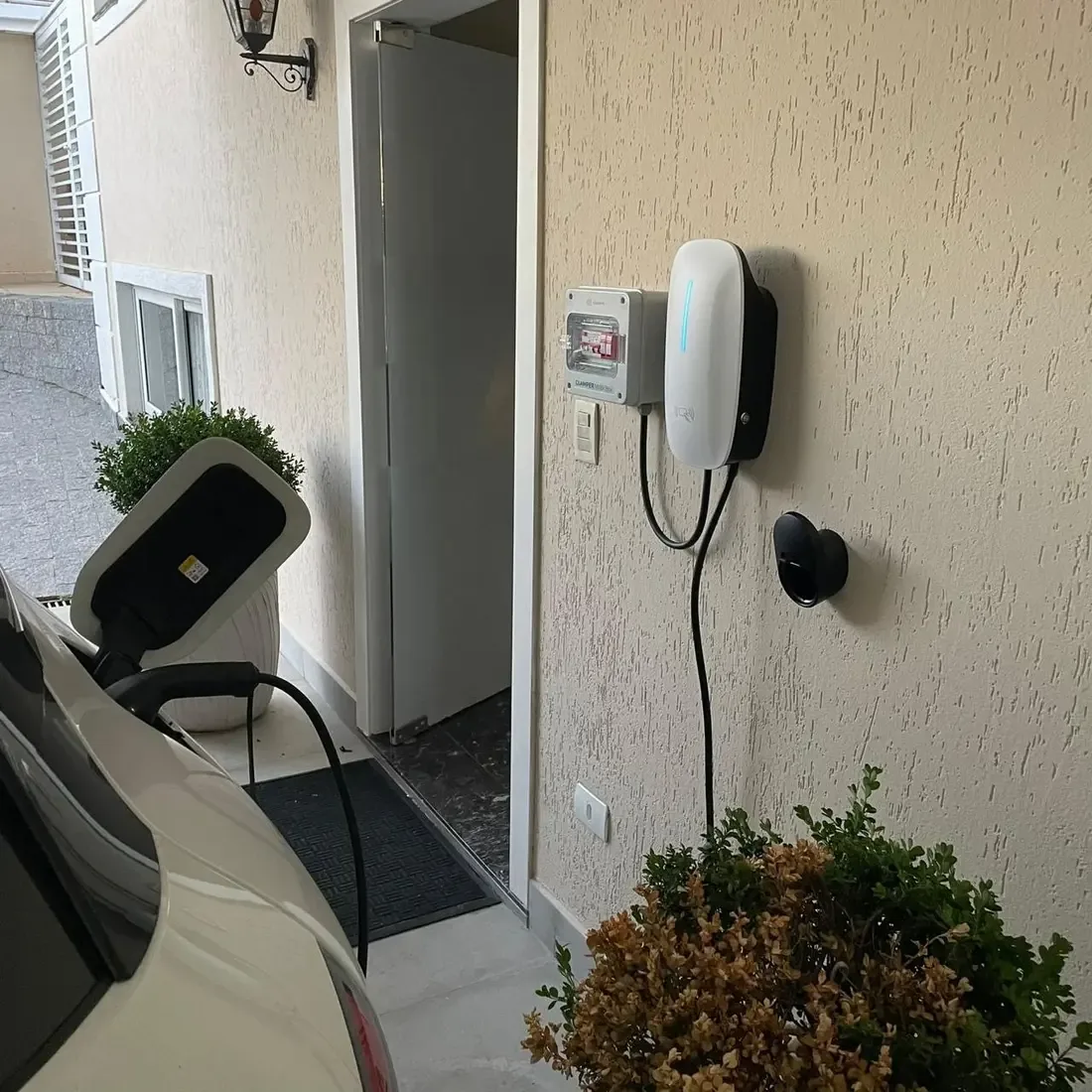 Carregador residencial instalado e conectado a veículo elétrico, segundo ângulo